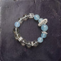 Z03 Glacial Vox bracelet — aquamarine, phantom quartz and pearl accent beads, flat lay on dark stone