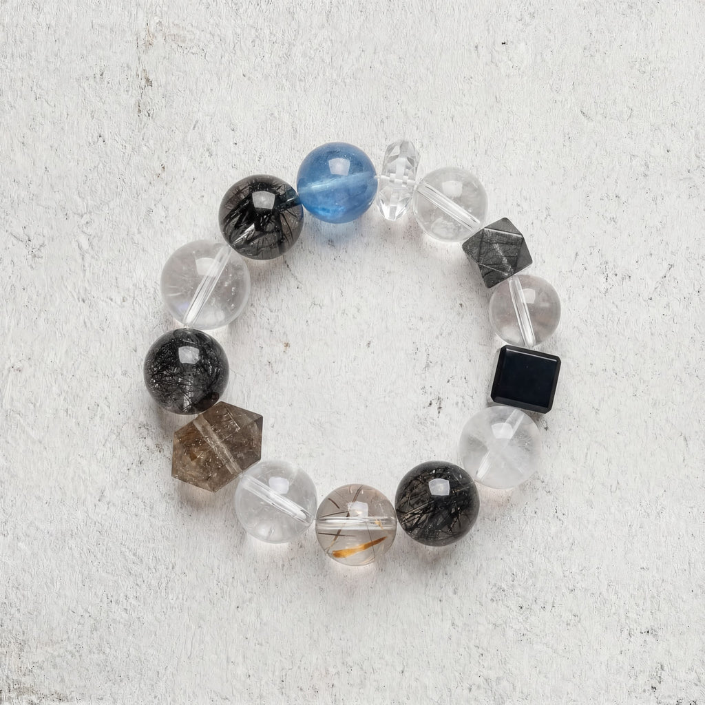 Z01 Ferro Barrier bracelet top-down on light gray — black rutilated quartz, clear quartz and aquamarine beads