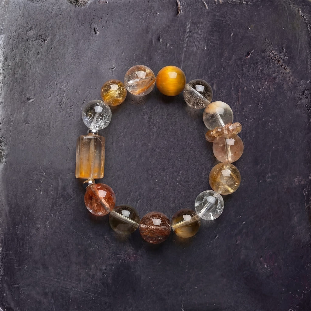 Z02 Aurum Complex bracelet — golden copper rutilated quartz and citrine beads, flat lay on dark stone